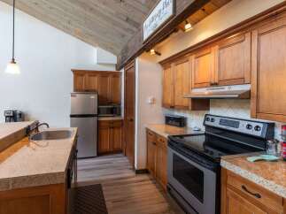 This charming kitchen boasts beautiful wooden cabinetry and a modern stainless steel appliance package.
