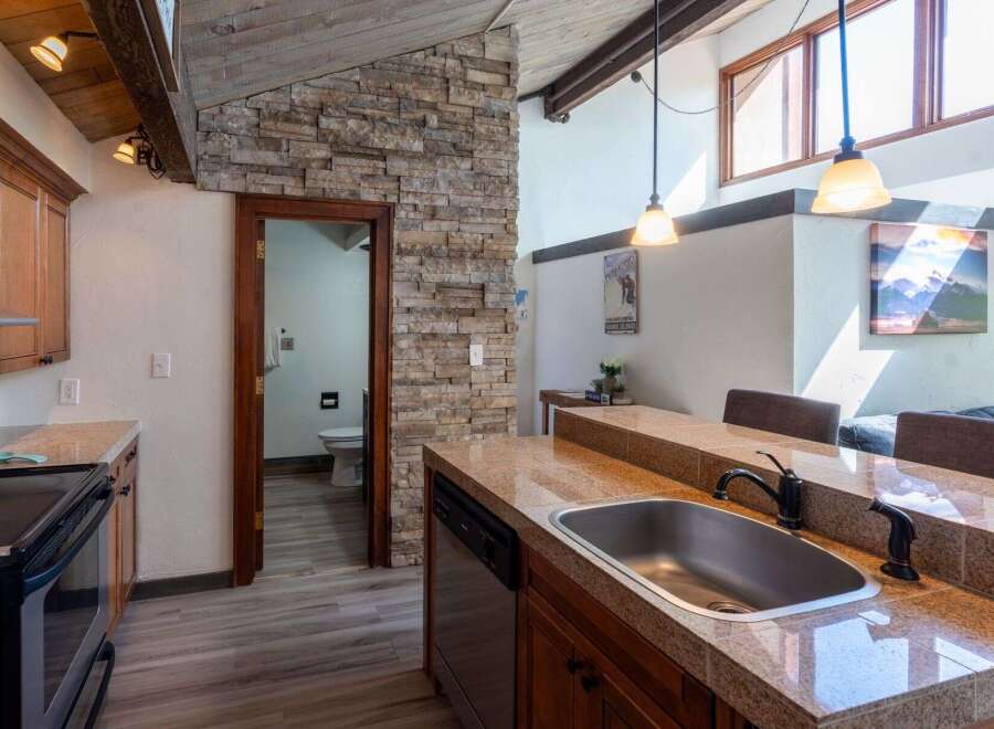 Discover the charm of this stunning kitchen, featuring a beautiful stone accent wall and modern appliances.