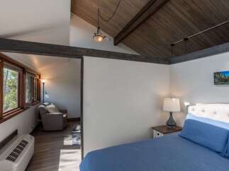 Discover the charm of this inviting bedroom, featuring a cozy seating area and a comfortable bed.