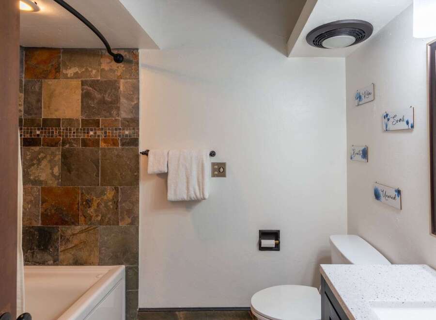 Step into a beautifully designed bathroom featuring a stylish tile shower and a modern vanity.