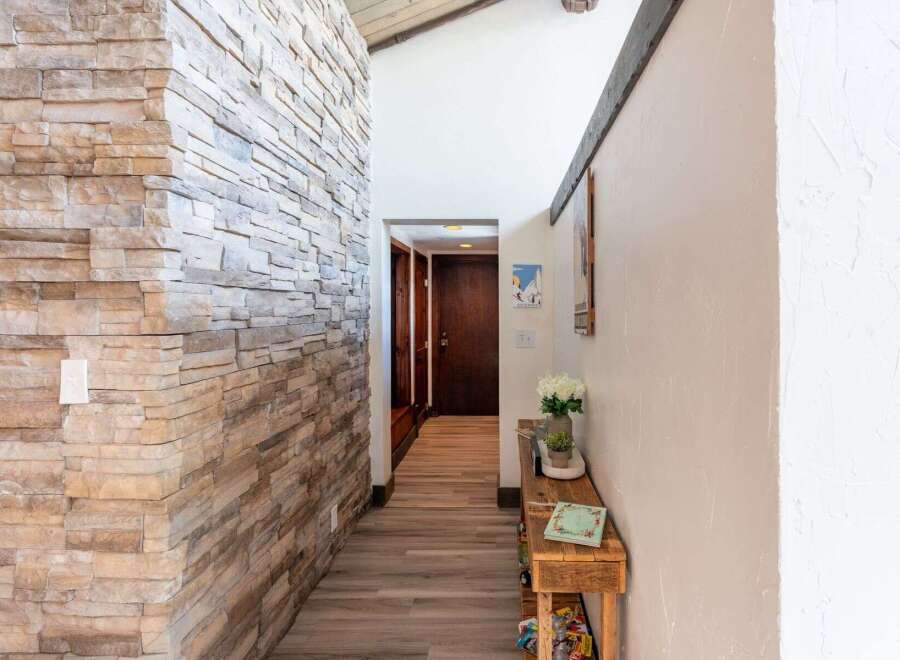 Step into a beautifully designed entryway featuring a stunning stone accent wall that adds a touch of rustic elegance.