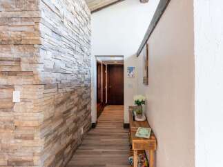 Step into a beautifully designed entryway featuring a stunning stone accent wall that adds a touch of rustic elegance.