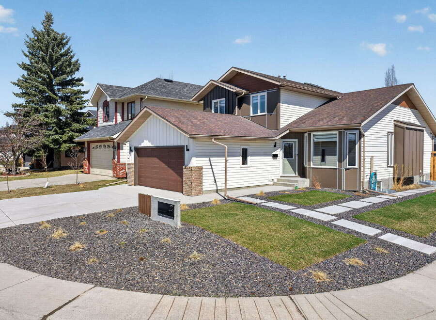 This stunning property boasts a modern exterior with a well-manicured lawn and stylish landscaping.