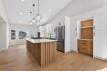 This stunning kitchen boasts a modern design with sleek white cabinetry and a striking wooden island.