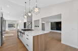 This stunning kitchen boasts modern design with sleek white cabinetry, a marble countertop, and a stylish island.