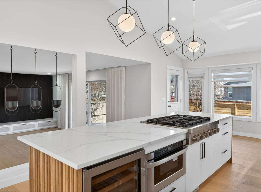 This stunning kitchen boasts a modern design with sleek white cabinetry and a spacious island, perfect for culinary enthusiasts.