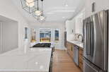 This stunning kitchen boasts modern design with sleek white cabinetry and a spacious island with a cooktop.