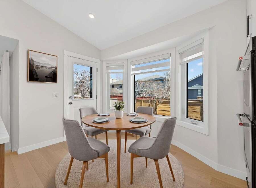 This stunning dining area features a round wooden table, perfect for intimate gatherings.