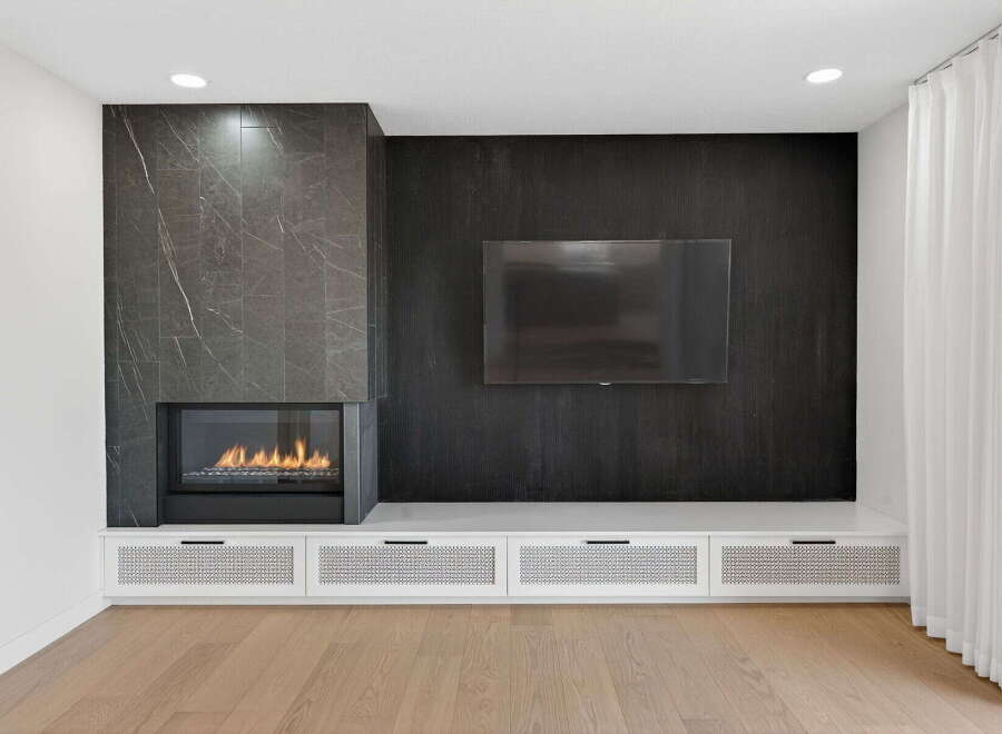 Experience luxury living in this stunning property, featuring a modern fireplace and a sleek entertainment center.