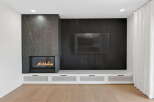Experience luxury living in this stunning property, featuring a modern fireplace and a sleek entertainment center.