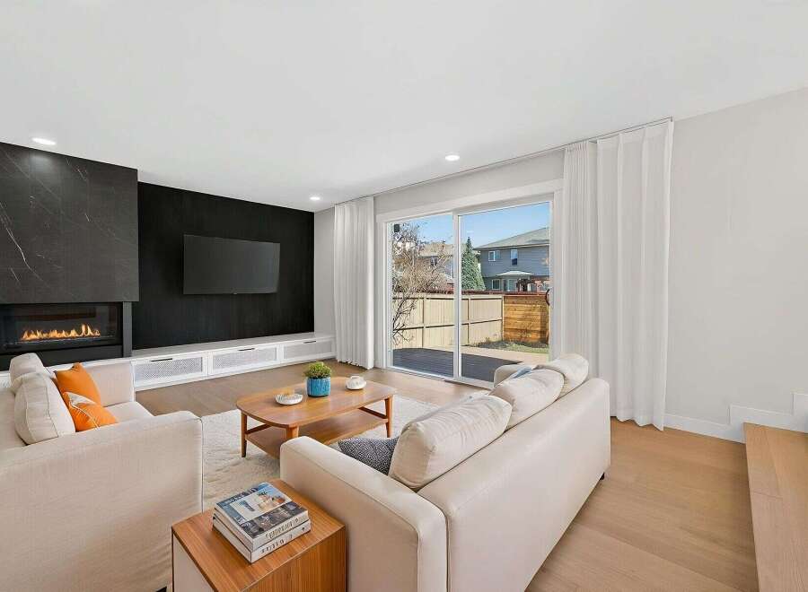 Experience luxury living in this stunning property featuring a modern fireplace and a sleek black accent wall.