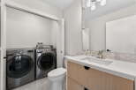 Discover modern living in this stunning property! Featuring a convenient laundry area with a washer and dryer, and a stylish bathroom with a sleek vanity and sink.