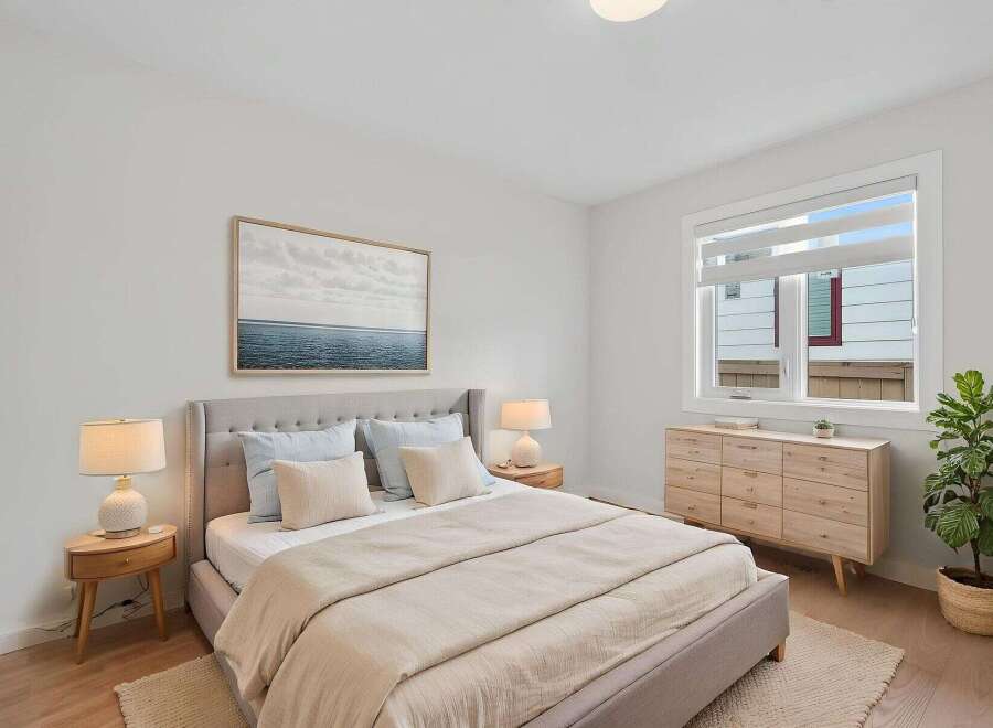 Step into this serene bedroom, featuring a comfortable bed with soft bedding and a calming color palette.