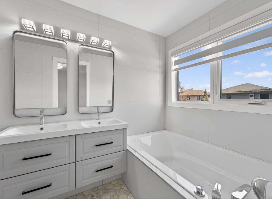 Step into luxury with this stunning bathroom featuring a sleek double vanity and modern design.