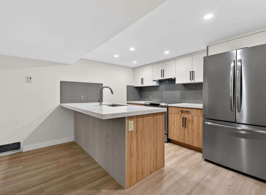 This modern kitchen boasts a sleek design with a spacious island, perfect for meal prep and entertaining.
