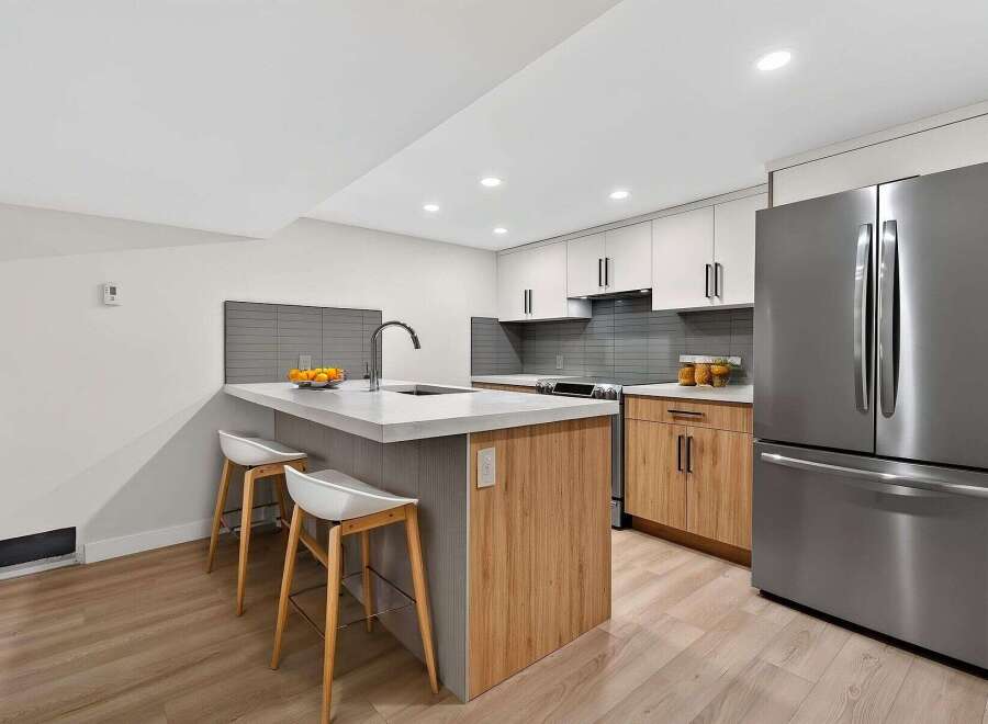 This modern kitchen boasts a sleek design with a spacious island, perfect for meal prep and entertaining.