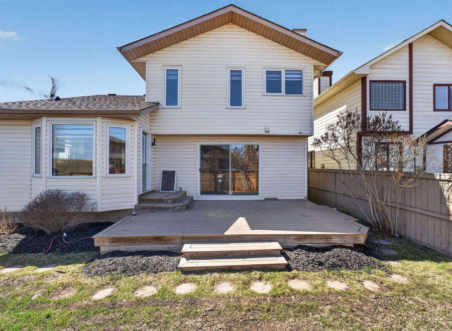 This stunning property boasts a spacious backyard with a large wooden deck, perfect for outdoor entertaining.