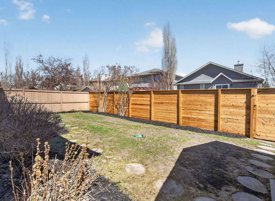 Enjoy the privacy of this beautifully landscaped backyard, complete with a modern wooden fence.