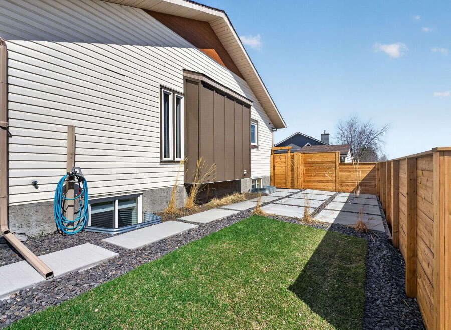 Discover the charm of this beautifully maintained property! This home features a well-manicured lawn, complemented by a stylish wooden fence that offers both privacy and aesthetic appeal.