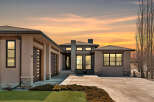 This stunning modern home boasts a sleek design with a spacious driveway and a beautifully landscaped front yard.