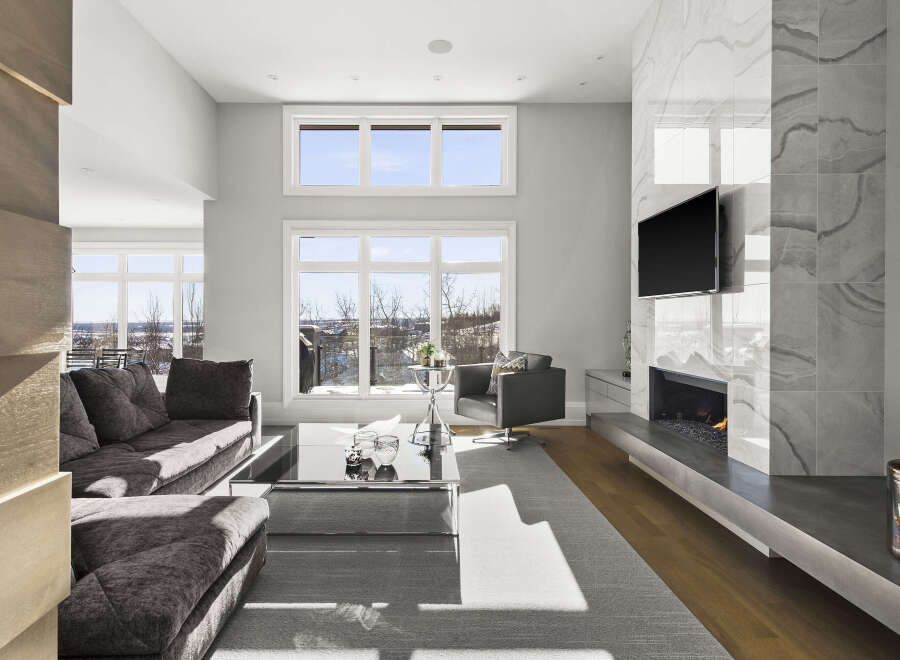 Experience luxury living in this stunning property featuring a modern fireplace and expansive windows that flood the space with natural light.