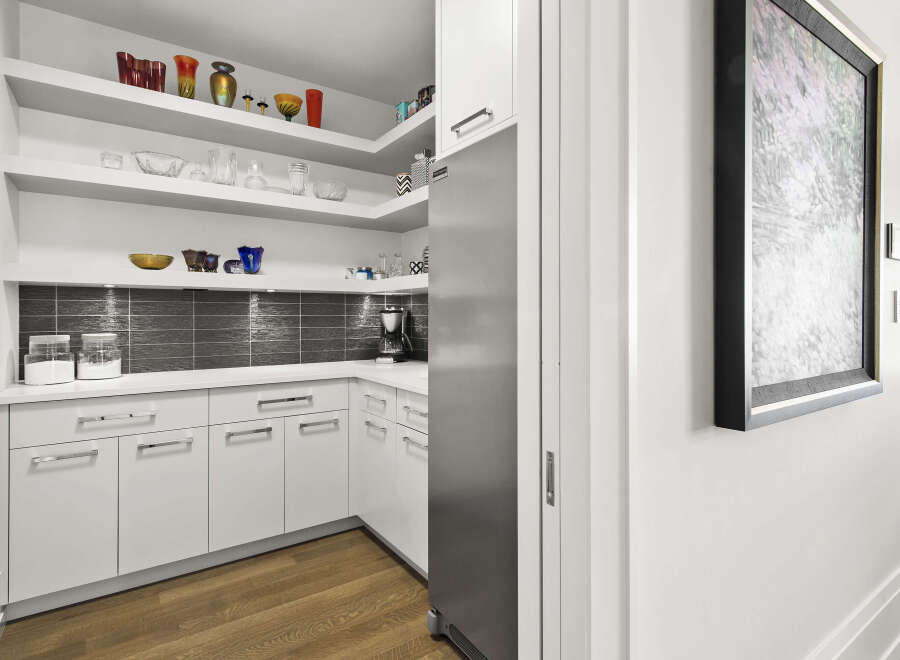 This modern kitchen boasts sleek white cabinetry and stainless steel appliances, creating a bright and inviting space.