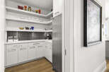 This modern kitchen boasts sleek white cabinetry and stainless steel appliances, creating a bright and inviting space.