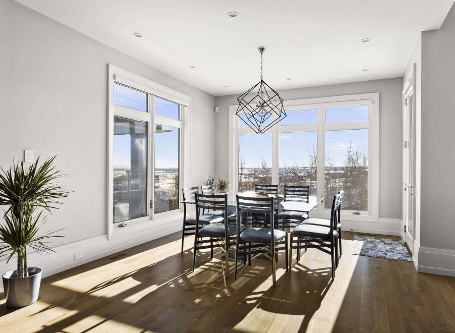 This stunning dining room boasts an abundance of natural light, thanks to the expansive windows that offer breathtaking views.