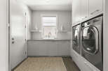 This modern laundry room boasts sleek, minimalist design with ample storage and functionality.