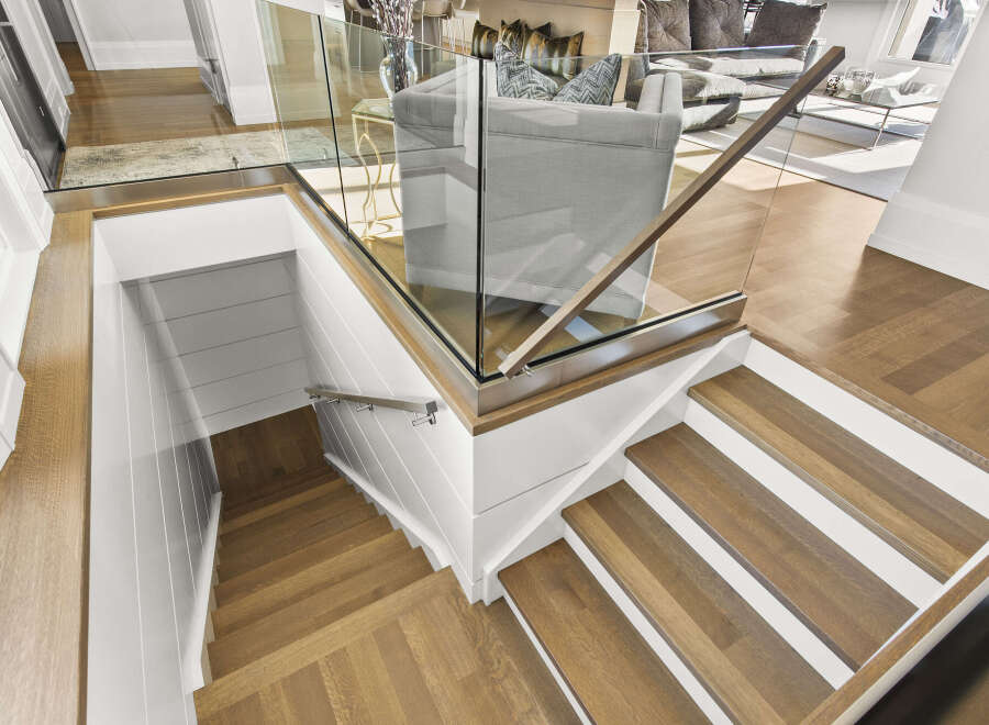 This stunning property boasts a modern staircase design, featuring elegant wooden steps and a sleek glass railing.