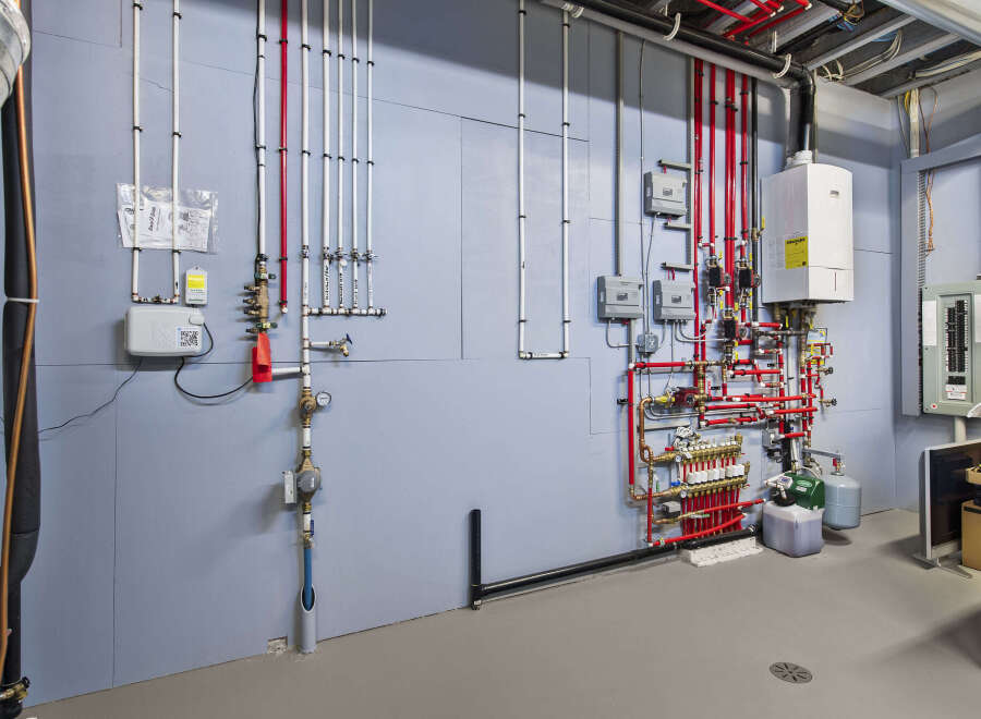 This utility room showcases a complex network of pipes and equipment, essential for a modern home's functionality.