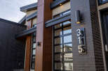This stunning modern home showcases a sleek design with a combination of wood and brick exterior.