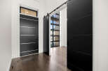 Step into modern elegance with this stunning property, featuring sleek black doors and a welcoming entryway.