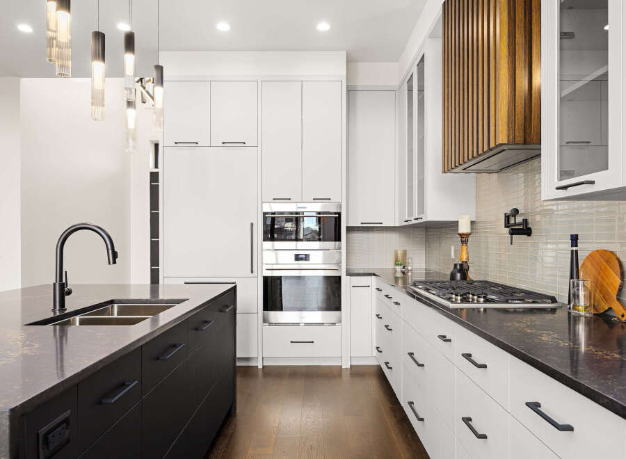 This stunning kitchen boasts modern design with sleek white cabinetry and a contrasting dark island.