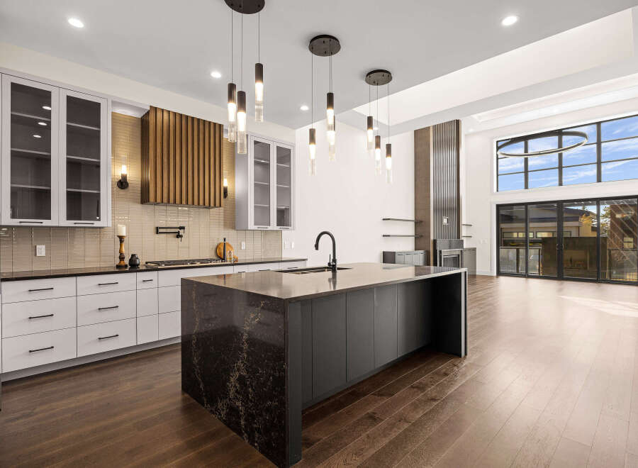 Experience luxury living in this stunning kitchen! Featuring a large island with a dark countertop, modern cabinetry, and sleek pendant lighting, this space is perfect for both cooking and entertaining.