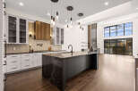 Experience luxury living in this stunning kitchen! Featuring a large island with a dark countertop, modern cabinetry, and sleek pendant lighting, this space is perfect for both cooking and entertaining.