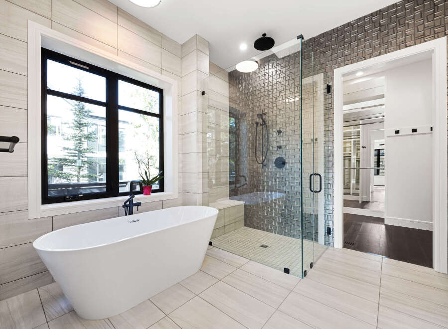 Step into luxury with this stunning bathroom! Featuring a sleek, modern design, this space boasts a freestanding tub, a glass-enclosed shower, and elegant tile work.