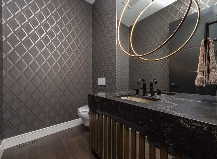 This stunning bathroom boasts a modern design with a dark countertop and a unique sink.