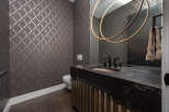 This stunning bathroom boasts a modern design with a dark countertop and a unique sink.