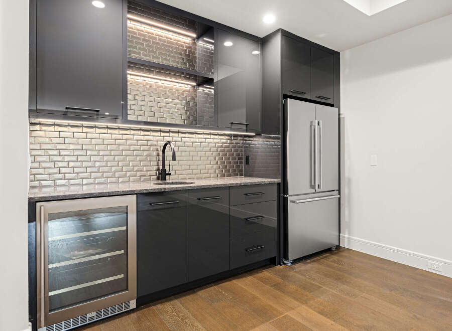 This stunning kitchen features sleek, modern design with dark cabinetry and stainless steel appliances.