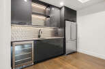 This stunning kitchen features sleek, modern design with dark cabinetry and stainless steel appliances.