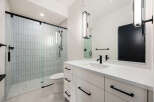 This modern bathroom features a sleek, minimalist design with a spacious walk-in shower and a stylish vanity.