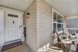 Welcome to your new home! This charming property features a welcoming front porch with a 'Welcome' sign and a cozy seating area.