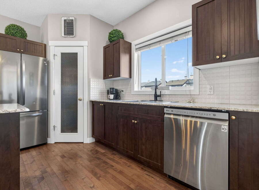 Step into this stunning kitchen, boasting rich, dark cabinetry and sleek stainless steel appliances.