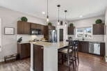 This stunning kitchen boasts dark wood cabinetry, a spacious island with seating, and elegant granite countertops.