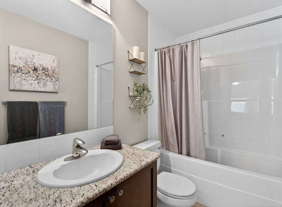 This beautiful bathroom features a modern design with a granite countertop and a sleek sink.