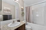 This beautiful bathroom features a modern design with a granite countertop and a sleek sink.