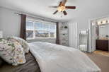 Step into this inviting bedroom, featuring a cozy bed adorned with decorative pillows and a stylish white quilt.