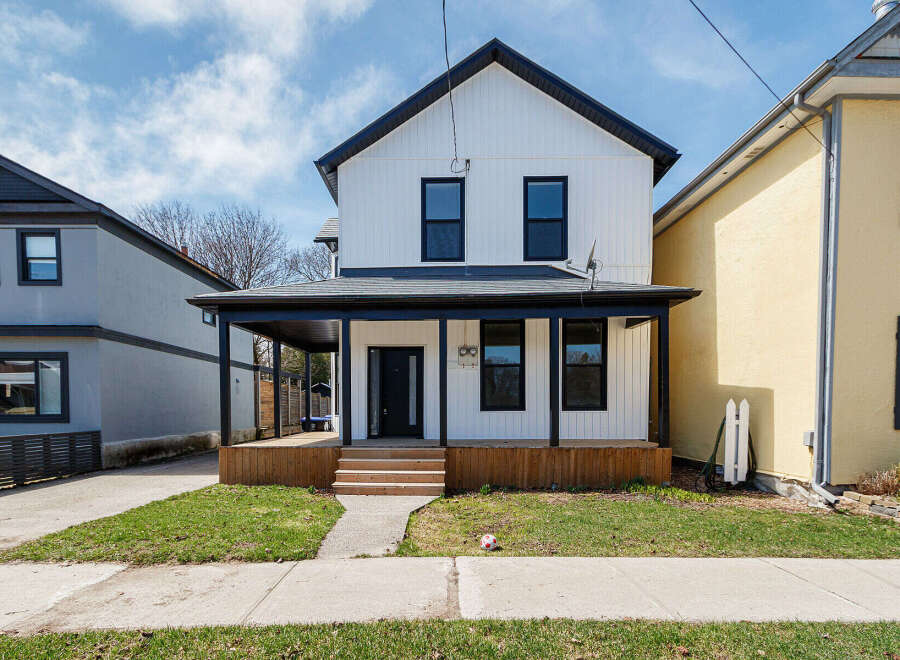This stunning two-story home boasts a modern farmhouse design with a welcoming front porch and a beautifully landscaped yard.