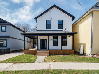 This stunning two-story home boasts a modern farmhouse design with a welcoming front porch and a beautifully landscaped yard.